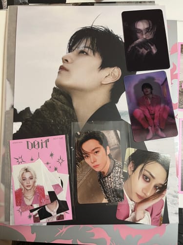 Customer's STRAY KIDS album laid out, showing the photobook and various photocards of the members included in the purchase.