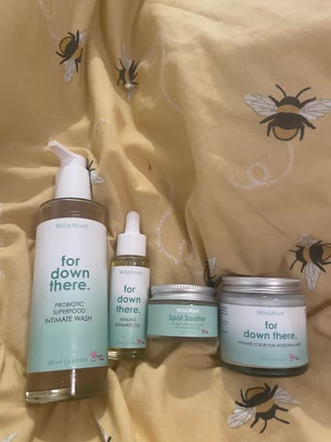Customer's Superfood Intimate Care Kit arranged on a yellow blanket with a bee print.