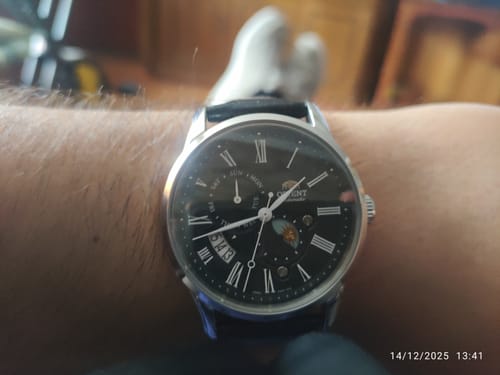 Reseñador mostrando su reloj Orient automático en la muñeca, destacando la esfera negra con sus distintas complicaciones.