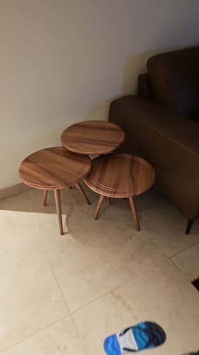 Customer's set of three Tamara tables with a natural wood finish, grouped together next to a sofa in a living room.