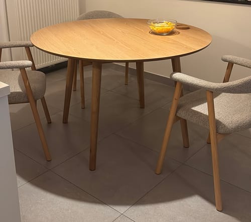 De ronde by fonQ basic eettafel van een klant, opgesteld in een eetkamer met drie grijze stoelen.