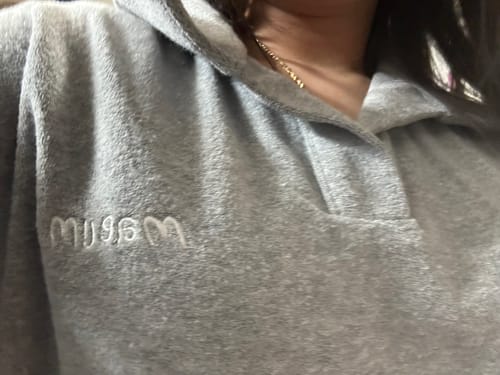 Close-up of a reviewer wearing the gray, soft Ever Soft Pajamas, showing the embroidered text on the chest.