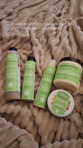 Photo d'un client montrant plusieurs produits du Pack routine Mango NOURISH sur une couverture douce.