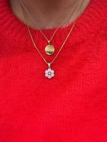 Customer wearing the gold Engravable Classic Disc Necklace layered with another necklace against a red sweater.