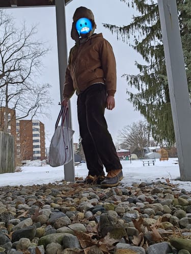 Reviewer wearing the brown Heavy-Duty Corduroy Work Pants and other winter gear while standing in a snowy area.