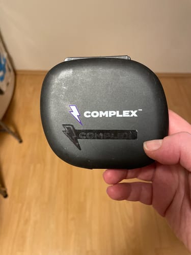 Reviewer's hand holding a black branded travel case for Complex Sleep Magnesium.