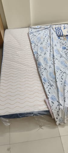Customer's Flo Mattress Ortho on the floor, showing the white, wavy-patterned top surface.