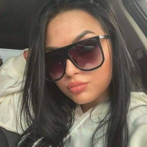 Close-up of a reviewer wearing the flattering, oversized Luxe Escape Black sunglasses.