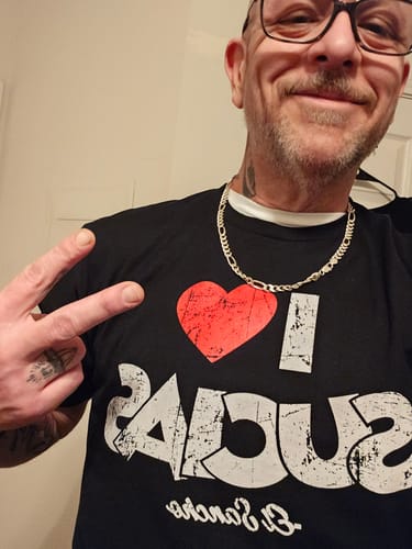 Reviewer smiling while wearing the black 'I Love Sucias - El Sancho' T-Shirt.