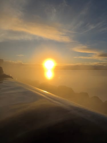 Customer photo of a golden sunrise over a steamy pool, taken with a phone protected by the Oasis Series waterproof case.