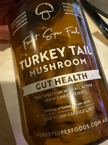 Customer holding a brown bottle of Turkey Tail Mushroom capsules from the Australian Grown Mushroom Bundle.
