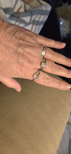 Customer's hand wearing the Forever Linked Ring on their ring finger, alongside two other rings.