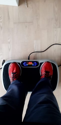 Anmelder står på sin vibrationstræner, set oppefra.