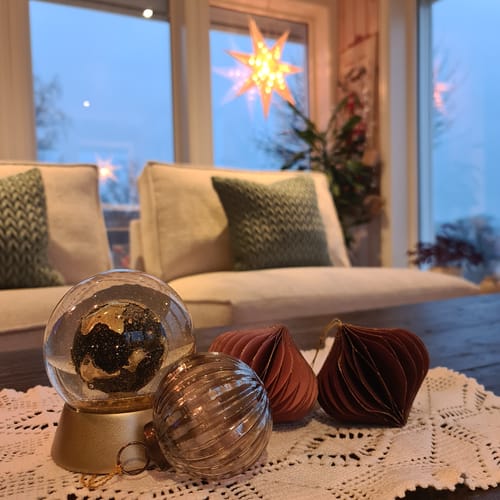 Anmelders løkformede julekuler i papir, arrangert på et stuebord med annen pynt.