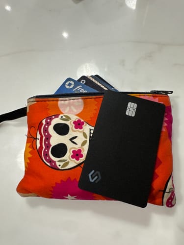 Reviewer showing the inconspicuous SPOTMINDERS Tracking Card PRO in a colorful, small wallet.