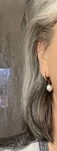 Nahaufnahme des Shine Pearl Ohrrings am Ohr einer Rezensentin, der die goldene Creole und den eleganten Perlenanhänger zeigt.