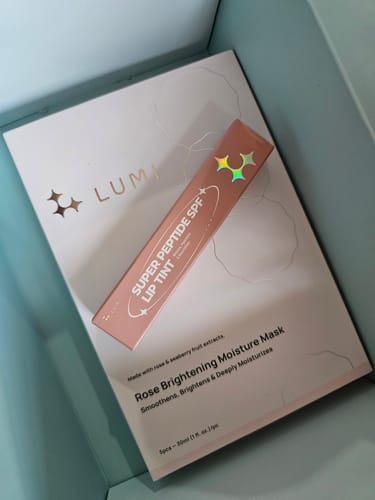 Customer's Super Peptide SPF Lip Tint packaging resting on another product inside a gift box.