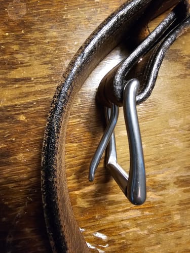 Close-up of the reviewer's dark Montana Bison Double Layer belt, highlighting the textured leather and steel buckle.