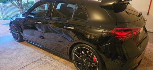Reviewer's shiny black car parked in a garage after using the Waterless Super Saver Kit.
