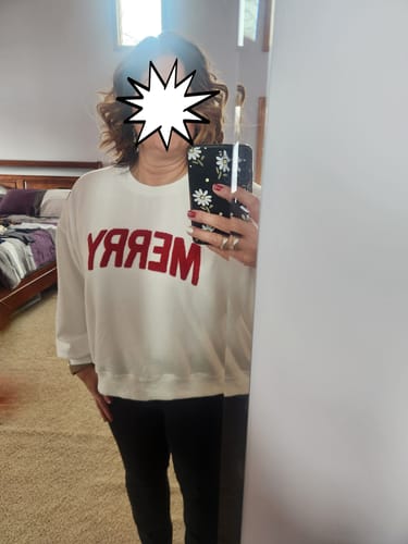 Reviewer taking a mirror selfie while wearing the white Merry Chenille Graphic Crewneck.