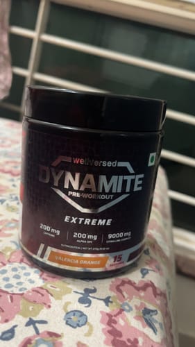 Customer's black tub of Dynamite Pre-Workout EXTREME in Valencia Orange, showing key ingredients on the label.