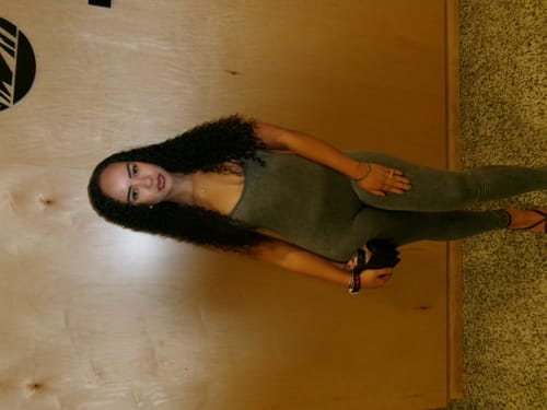 Reviewer posing indoors while wearing the grey Seamless Body Harness.