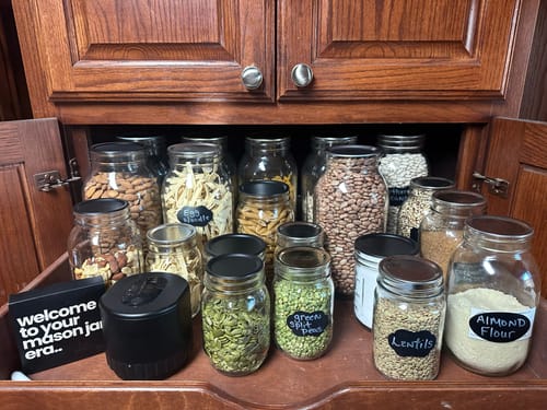Customer's Mason Genie® Vacuum Sealer in a pantry surrounded by sealed jars of dry goods.