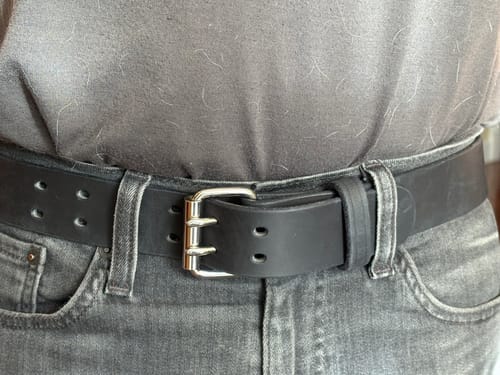 Customer wearing the black Legend Double Prong Retro Style belt with a silver buckle and grey jeans.