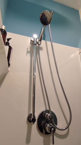 Reviewer's installed chrome 3-Spray Hand Held Shower Head Set with Slide Bar in a white shower stall.