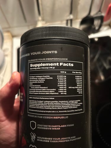 Customer holding the black tub of Complex Joint Care Ultra, showing a close-up of the Supplement Facts label.