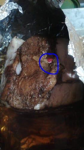 Primer plano del Rib Eye a las Finas Hierbas del reseñador, cocido en papel aluminio, con el termómetro sin botar.