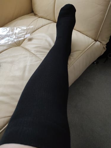 Customer wearing the long, black Performance Eucalyptus Compression Socks, showing the fit on their leg.