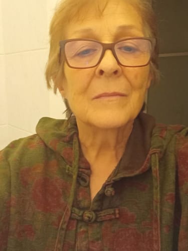 Close-up of a reviewer wearing the green and red vintage flower hooded top from the suit.