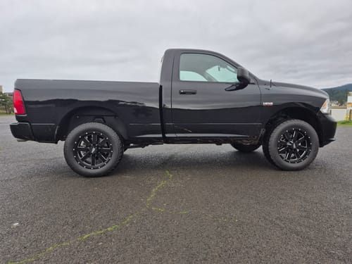 Customer's lifted black pickup truck, side view, after installing the Upper Control Arm and Lift Kit.