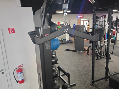 Customer's black Multi Grip Handle attached to a cable pulldown machine in a gym.