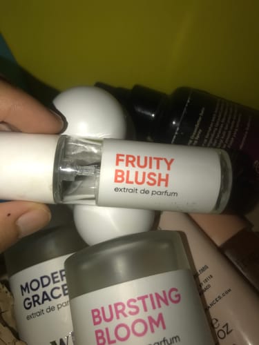 Customer holding one of several small perfume bottles included in the Mystery Gift.