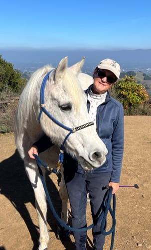 Reviewer standing with her senior white Arabian mare mentioned in her Osteo-MAX review.