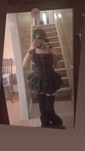 Reviewer poses in a mirror wearing the dark Grunge Doll Stripes Flared Romper Dress, showing its flared silhouette.