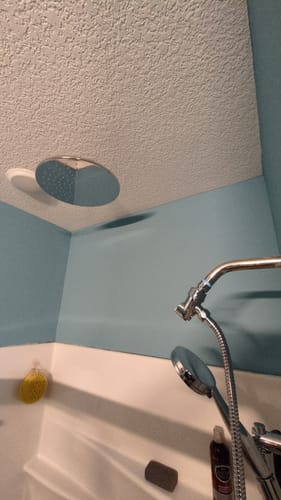 Customer's large 12 Inch Rain Shower Head installed flush against a textured ceiling in their shower.