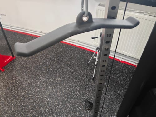 Customer's dark Tricepatops Push Down Bar attached to a cable machine in a home gym.