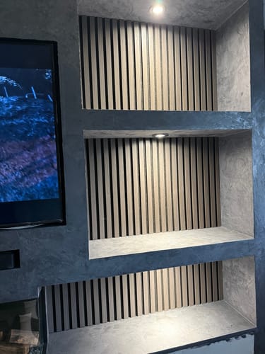 Customer's light wood Premium Acoustic Slatted Wall Panels installed inside grey recessed media shelves.