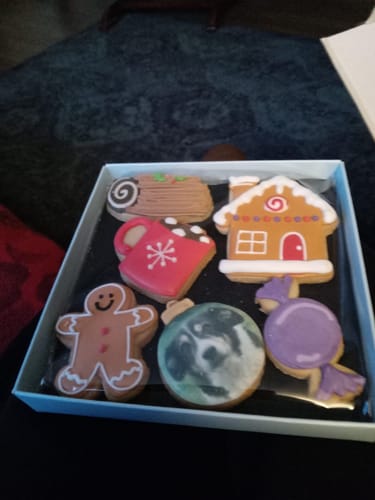 Customer's photo of a box of assorted decorated Christmas biscuits, including one with a custom photo.