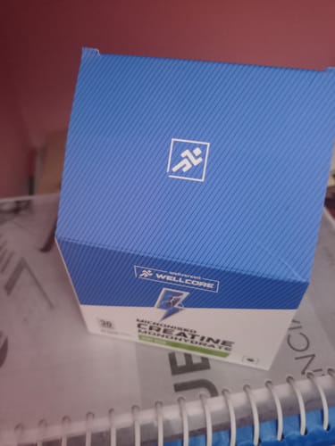 Customer's blue and white box of Wellcore Pure Micronised Creatine Monohydrate sachets, seen from an angle.