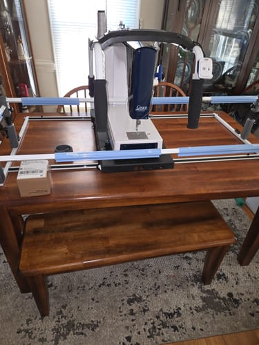 Reviewer's Q'nique 13 Little Rebel Sewing Machine assembled with its frame on a wooden dining table.