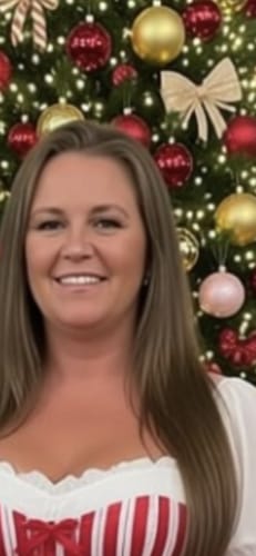 Reviewer smiling in front of a Christmas tree, the product is not visible.