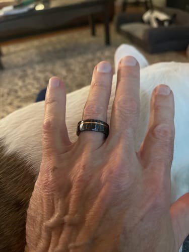 Customer wearing The Stormlight ring, showing the hammered black band with a rose gold inlay on their hand.