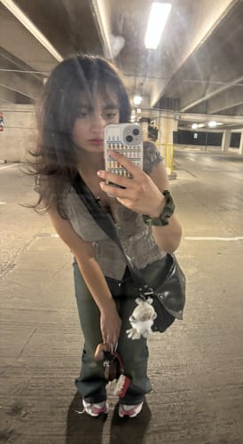 Reviewer takes a mirror selfie wearing the Oveline Shadow Grey Eyelet Ruffle Blouse Top in a parking garage.