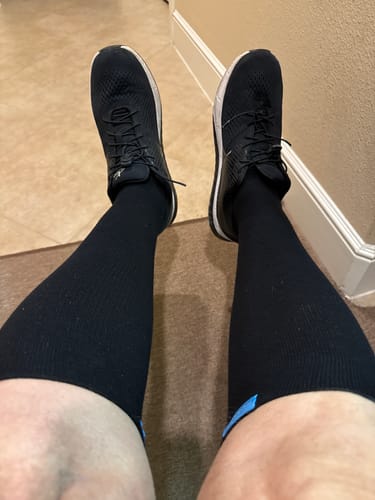 Reviewer's view of their legs while wearing the long black Performance Eucalyptus Compression Socks.