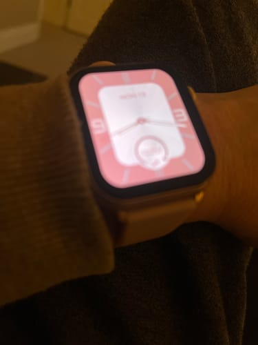 Close-up of a reviewer's Gard Pro Health Smartwatch 3 on a wrist, showing a customized pink watch face.