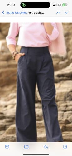 Une cliente porte le pantalon Tom marine à coupe large, avec une main dans la poche.